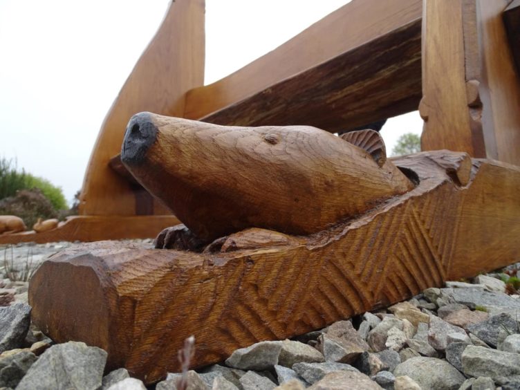 His benches are ornately decorated with carvings and sculptures, like this bear