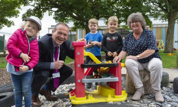 Laurence Findlay, Aberdeenshire Council's director of education and Gillian Owen, education committee chairwoman, with children at the new Fishermoss School nursery.