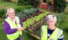 Julie-Ann Henderson (left) is teaching Emma Wood how to grow vegetables.