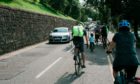 Cyclists using the Spaces for People measures below Inverness Castle.