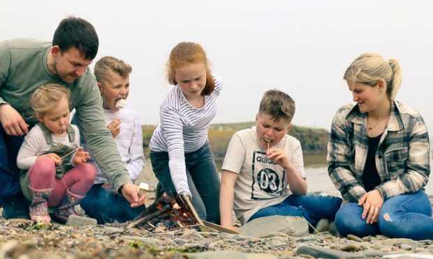 The Nicolson family test out their dad's homemade marshmallows on a campfire. From left: Camrynn, Gary, Blaine, Cailynn, Balfour and Charlene Nicolson.