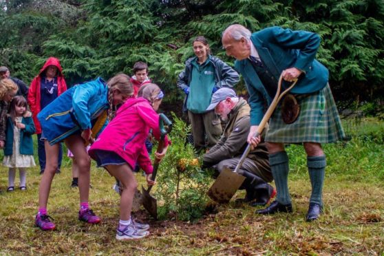 Local children with Andrew Peters, tree specialist and Lord Macdonald planting endangered conifers in Skye. Picture by Paddy McKay