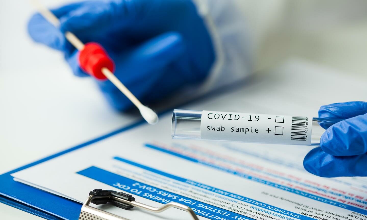 A Covid swab is inserted into a test tube
