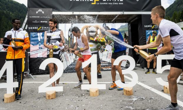 Winner Kilian Jornet of Spain (C) celebrates on the podium of the men's category with Lengen Lolkurraru of Kenya, Robbie Simpson of Britain, Cesare Maestri of Italy, and Davide Magnini of Italy (L-R) during the 48th Sierre-Zinal long distance mountain race in Zinal, Switzerland.
