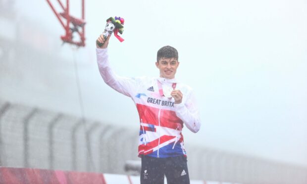 Fin Graham celebrates with his silver medal on the podium.