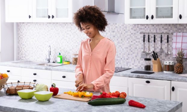 A woman chopping healthy fruit and veg, a leading tip of how to boost immune system