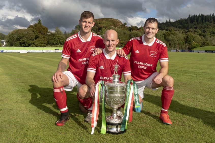 Kinlochshiel's MacRae brothers, John, Keith and Finlay, with the shinty Camanachd Cup in 2021