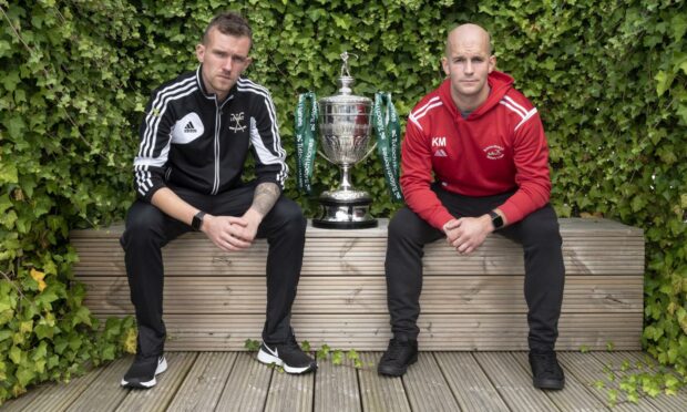 Lovat captain, Stuart MacDonald (left) and Keith MacRae, Kinlochshiel captain, sit either side of the Tulloch Homes Camanachd Cup ahead of this Saturday's 125th Anniversary final at Mossfield, Oban.