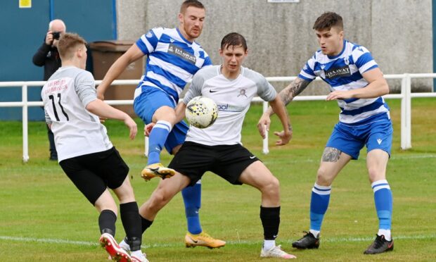 Culter's Nicky Wozniak with the ball, surrounded by Dyce defenders. Picture by Kenny Elrick
