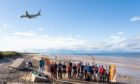 Volunteers from RAF Lossiemouth clearing their local beach, with a Poseidon aircraft flying overhead. Photo credit: RAF Lossiemouth.
