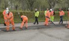 Workers with a pothole repairing machine at a car park in Alness.
