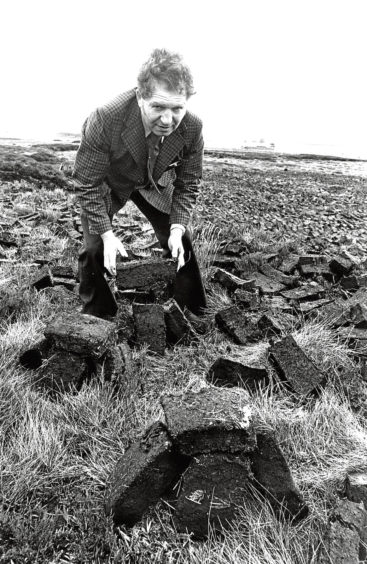 1977: Scott Smith shows off some peat cuttings at New Pitsligo.