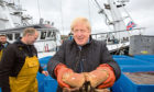 Prime Minister Boris Johnson holds crabs caught on the Carvela with Karl Adamson at Stromness Harbour