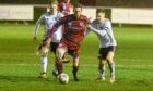 Keith's James Brownie, centre, tries to hold off Formartine's Graeme Rodger, right, and Cole Anderson