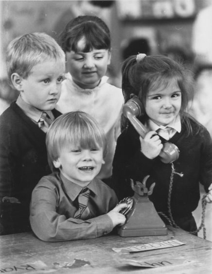 1987: It's for you primary one pupil at Torry's Victoria Road Primary School, Claire Cowe puts a call through to her mum with some dialling help from Martin Douglas (centre) while Stuart McKenzie and Sarah Walker hang on.