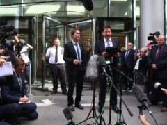 Sir Cliff Richard (centre) with his lawyer Gideon Benaim outside court (Victoria Jones/PA)