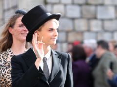 Cara Delevingne wears bold top hat and tails to the royal wedding (Gareth Fuller/PA)