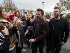 Shane Filan high fives a fan as he walks with band member, Kian Egan and Markus Feehily of Westlife at the SSE Arena, Belfast, ahead of the press conference for tickets going on sale for their reunion tour