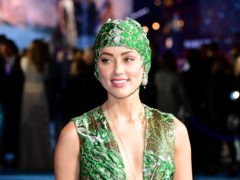 Amber Heard turned heads at the Aquaman premiere by arriving on the blue carpet wearing an emerald cap and gown (Ian West/PA Wire)