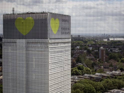 A banner with a green heart is wrapped around the Grenfell Tower one year on since the blaze, which claimed 72 lives (Victoria Jones/PA)