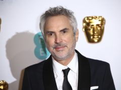 Alfonso Cuaron with his best film and best director Baftas (Ian West/PA)