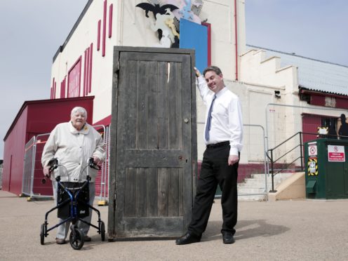 Cinema manager Neil Bates and Joyce Dowding with the door that inspired Larry Grayson’s famous catchphrase ‘Shut that door’ at the Regent Cinema in Redcar (Stuart Boulton/PA)