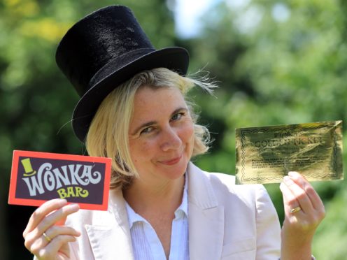 Auctioneer Catherine Southon holds the Golden Ticket and Wonka Bar props from the 1971 film Willy Wonka & The Chocolate Factory, which are going under the hammer (Gareth Fuller/PA)