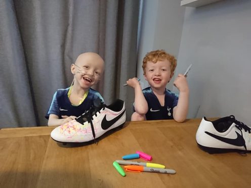 Archie Wilks colouring in his dad’s football boots with twin brother Henry (Family handout/PA)