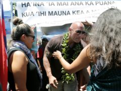 Actor Dwayne “The Rock” Johnson visits with kupuna, an honoured elder, during a visit to the protest site blocking the construction of the TMT telescope (Jamm Aquino/Honolulu Star-Advertiser/AP)