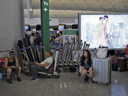 Stranded travellers wait in the departure hall of the Hong Kong International Airport (Vincent Thian/AP)