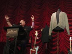 Auctioneer Deninis Kruse for Julien’s Auctions with Kurt Cobain sweater and guitar (David Willems/PA)