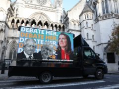 An advertising van showing Prime Minister Boris Johnson, Labour Party leader Jeremy Corbyn and Liberal Democrat leader Jo Swinson, outside the Royal Courts of Justice, London (Isabel Infantes/PA)