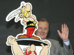 French author and illustrator Albert Uderzo waves from behind a cardboard cutout showing his comic heroes Asterix and Obelix (Joerg Sarbach/AP)