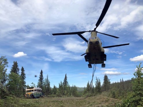 Soldiers use a Chinook helicopter to removed an abandoned bus out of its location in the Alaska back country (Sgt Seth LaCount/Alaska National Guard via AP)