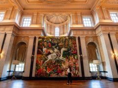 A visitor observes The Triumph of Death, Cecily Brown’s largest painting to date (Jacob King/PA)