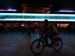 A cyclist rides past a sign saying ‘Welcome Back! We’ve Missed You’ displayed above the front of the BFI Southbank cinema in London (Yui Mok/PA)