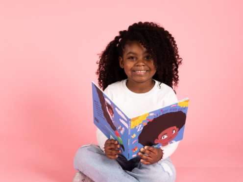 A child reading Let Out Your Hair by Trish Cooke (Tangle Teezer/PA)