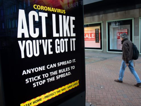A person passes an ‘Act like you’ve got it’ coronavirus sign on Old Christchurch Road in Bournemouth (Andrew Matthews/PA)