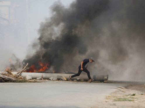 A man runs past a road barricade and burning debris Monday, March 22, 2021, in Mandalay, Myanmar. The BBC said Monday that a journalist from its Burmese-language service was released by authorities in Myanmar but gave no details, as protesters in the Southeast Asian nation continued their broad civil disobedience movement against last month’s military coup. (AP Photo)
