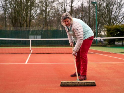 Ruth Williams, welfare officer and ladies captain brushes the courts at Wycombe House Tennis Club in Isleworth, London (John Walton/PA)