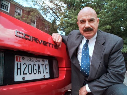 G Gordon Liddy kneels next to his Corvette in this 1997 photo (Ron Edmonds/AP)