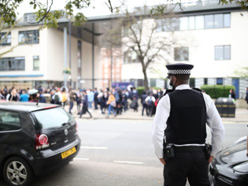 A police officer outside Pimlico Academy in London where pupils staged a walkout (Aaron Chown/PA)