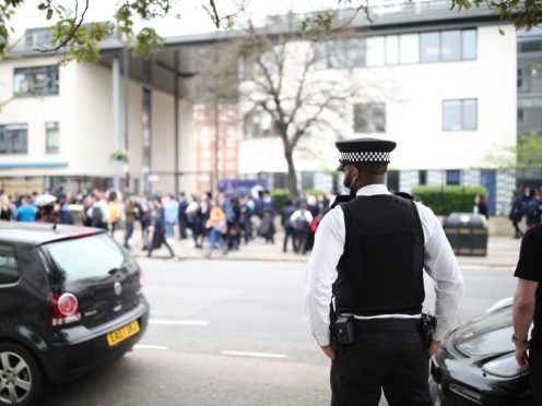 A police officer watches the demonstration outside Pimlico Academy in London (Aaron Chown, PA)
