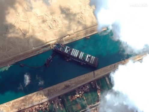 This satellite image from Maxar Technologies shows the cargo ship MV Ever Given stuck in the Suez Canal near Suez, Egypt, Friday, March 26, 2021. A maritime traffic jam grew to more than 200 vessels Friday outside the Suez Canal and some vessels began changing course as dredgers worked frantically to free a giant container ship that is stuck sideways in the waterway and disrupting global shipping. (©Maxar Technologies via AP)