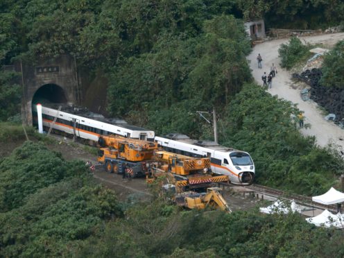 Rescue workers remove part of the derailed train (Chiang Ying-ying/AP)