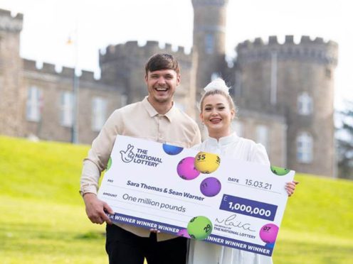Sara Thomas with her partner Sean Warner, celebrating after she won on a National Lottery Scratchcard (Camelot)
