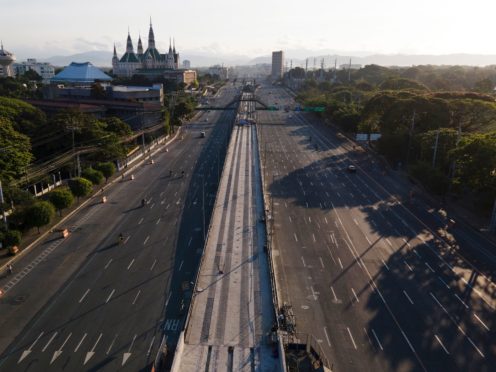 Motorist traverse an almost empty Commonwealth Avenue as the government implements a strict lockdown to prevent the spread of coronavirus in Quezon city, Philippines (Aaron Favila/AP)
