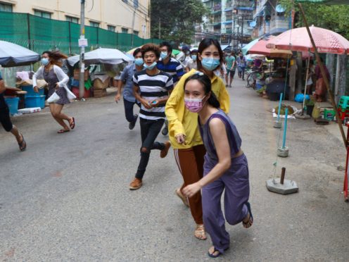 Anti-coup protesters run after seeing police and soldiers arrive to disperse their demonstration in Yangon, Myanmar (AP)