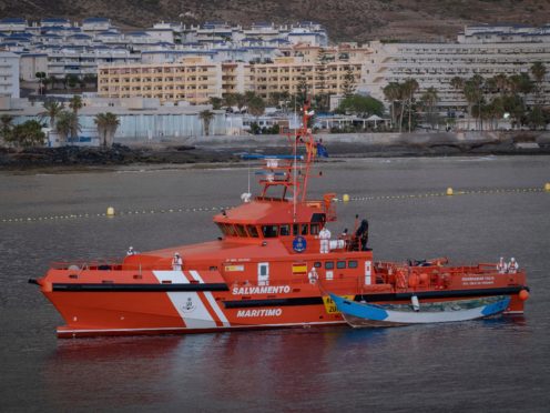 A wooden boat is towed by a Spanish Maritime Rescue Service ship (Andres Gutierrez/AP)
