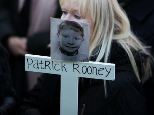 Sharon Moore, sister of Patrick Rooney who was nine when he was killed in Divis flats in 1969, holds a cross with his photo as survivors, victims and relatives of those killed in Troubles-related incidents took part in the ‘Time for Truth’ campaign’s march in Belfast (Brian Lawless/PA)